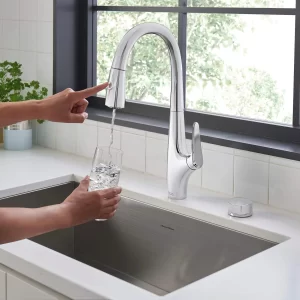 Filling glass with Saybrook Filtered kitchen faucet available at Benner Plumbing & Heating LTD