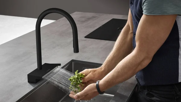 Washing herbs under modern Hansgrohe kitchen faucet